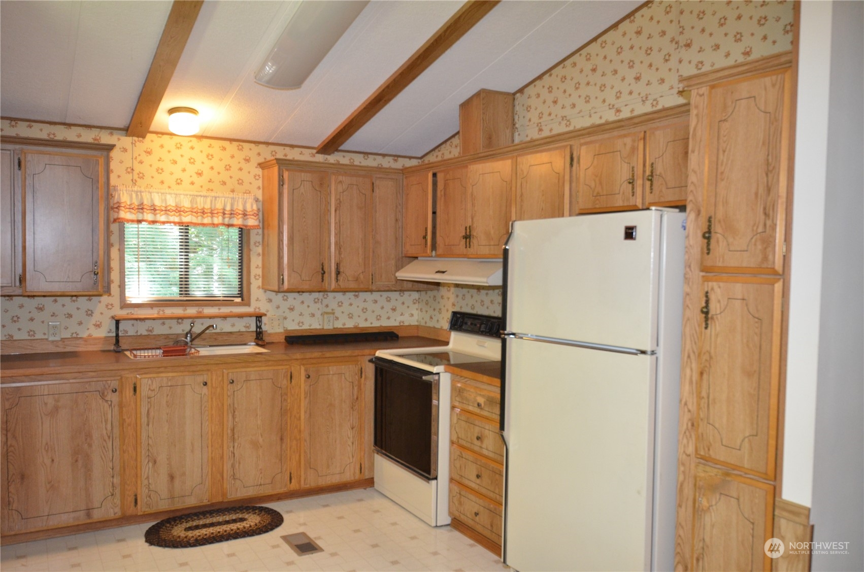 12712 Northeast 199th Street Bothell, WA 98011 - Photo 4 of 21 a kitchen with a refrigerator sink stove and cabinets