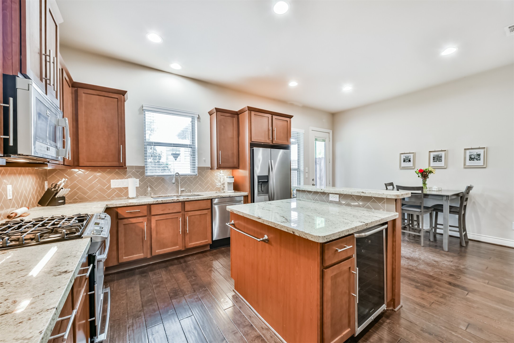 1321 Laird Street Houston, TX 77008 - Photo 7 of 25 Secondary view shows the island bar, wine refrigerator, SS appliances, designer backsplash and under cabinet lighting.