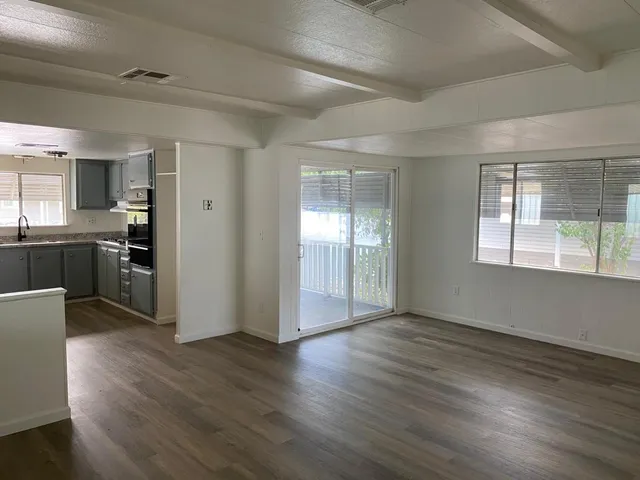 a view of a kitchen with wooden floor and electronic appliances
