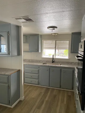 a kitchen with granite countertop cabinets stainless steel appliances a sink and a window