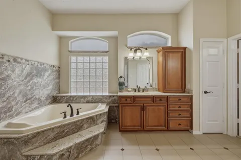 a large bathroom with a double vanity sink a mirror and a bathtub