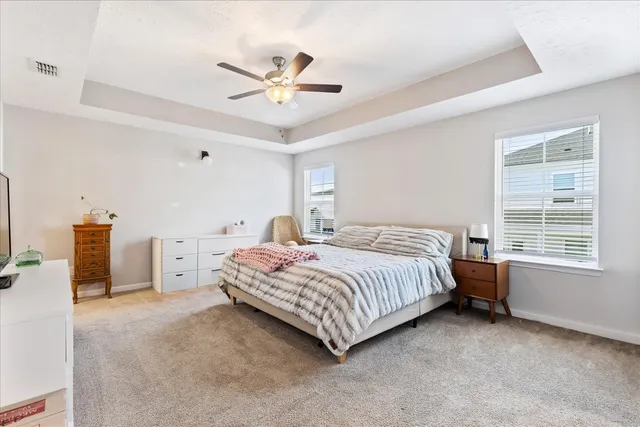 a spacious bedroom with a bed and a chandelier
