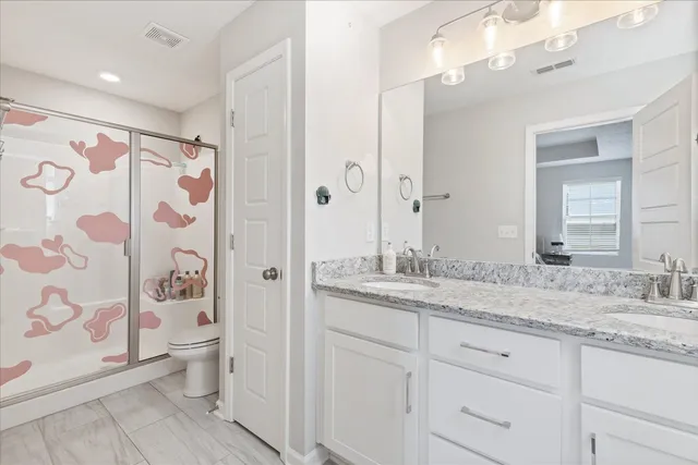 a bathroom with a granite countertop sink toilet and shower