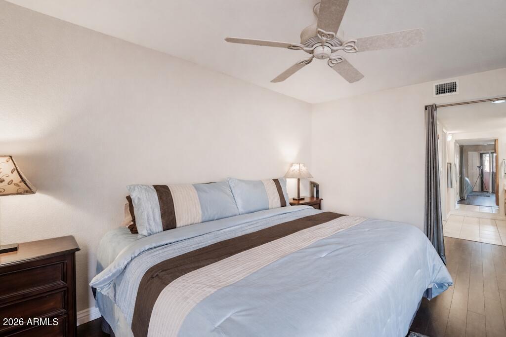 4303 East Cactus Road, Unit 403 Phoenix, AZ 85032 - Photo 14 of 37 a bedroom with a bed and a chandelier