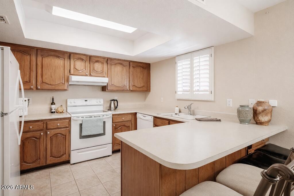 4303 East Cactus Road, Unit 403 Phoenix, AZ 85032 - Photo 9 of 37 a kitchen with a stove a sink and a refrigerator