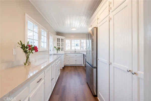 a bathroom with a granite countertop sink a toilet and a window