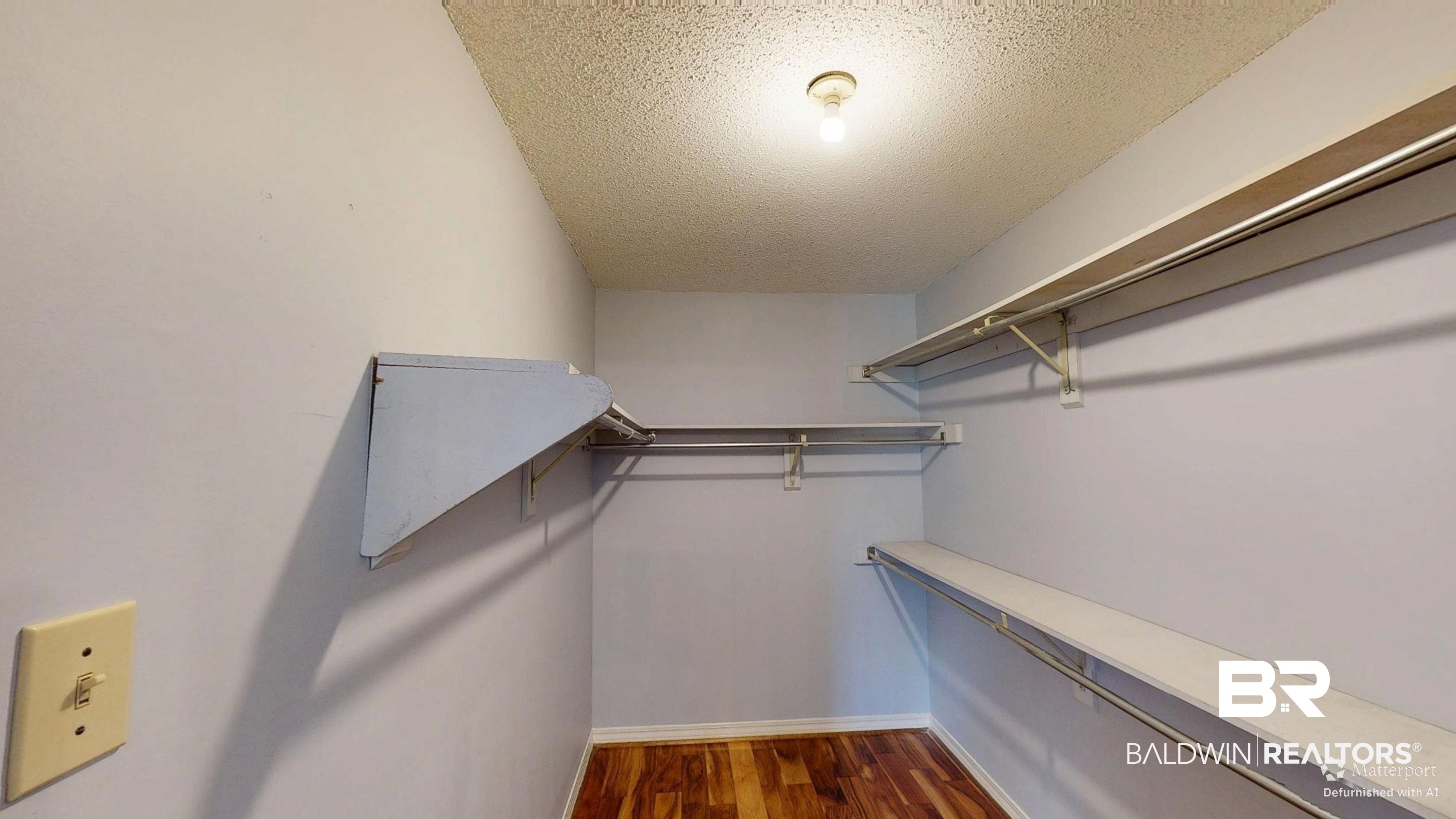 7310 Cheryl Court Mobile, AL 36695 - Photo 17 of 23 Walk in closet in primary featuring dark wood finished floors