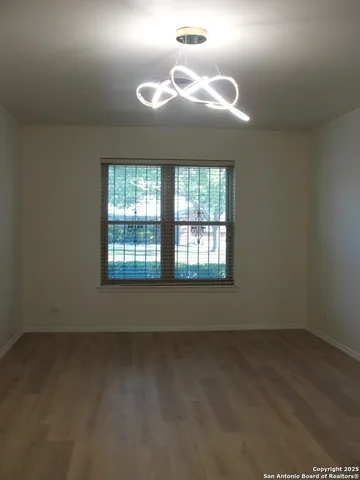 en empty room with windows and wooden floor