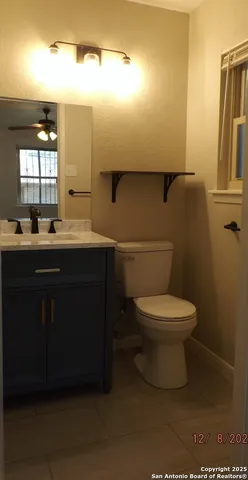 a bathroom with a granite countertop bathtub shower sink vanity and toilet