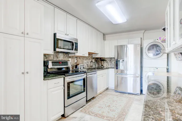 a kitchen with stainless steel appliances granite countertop a refrigerator a stove top oven a sink and dishwasher