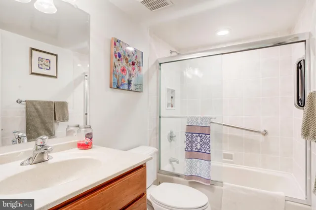 a bathroom with a sink vanity mirror and toilet