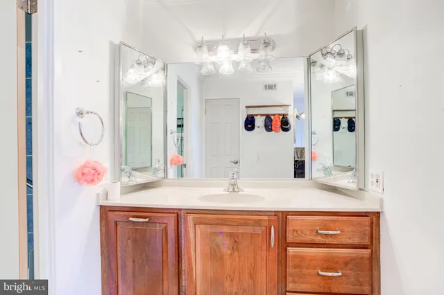 a bathroom with a sink vanity and a mirror