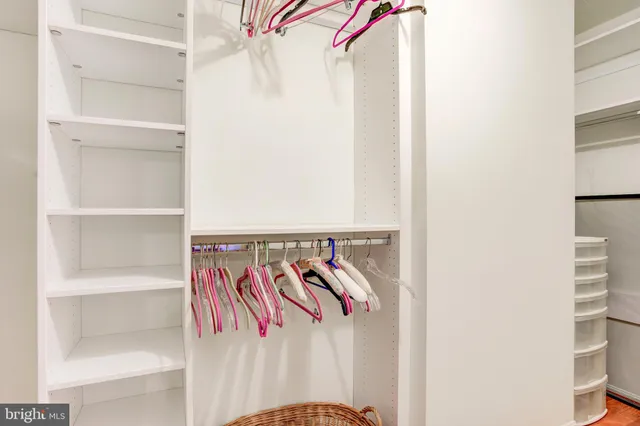 a view of a walk in closet with clothes