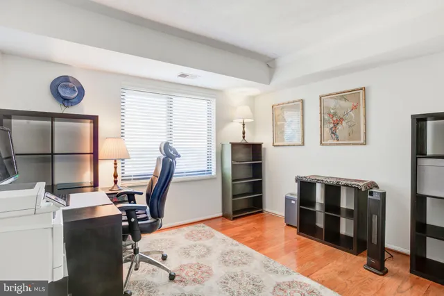 a view of a workspace with furniture and a window