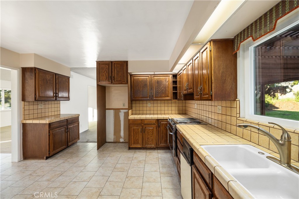 13402 Winthrope Street North Tustin, CA 92705 - Photo 16 of 34 a kitchen with stainless steel appliances granite countertop a sink stove and refrigerator