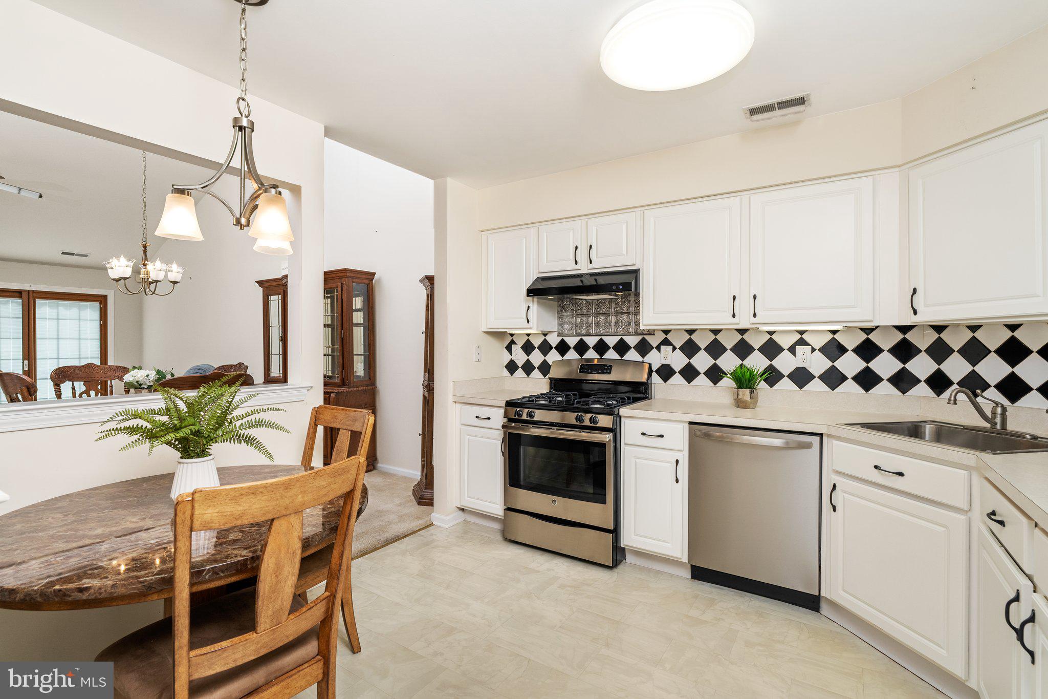 26 Brecht Road Hamilton, NJ 08690 - Photo 4 of 25 a kitchen with stainless steel appliances a white table chairs and a refrigerator