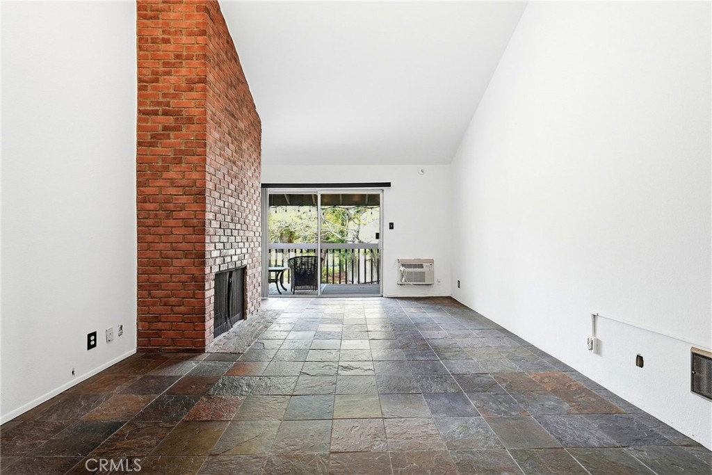 7890 East Spring Street, Unit 11E Long Beach, CA 90815 - Photo 3 of 40 a view of an empty room with a fireplace