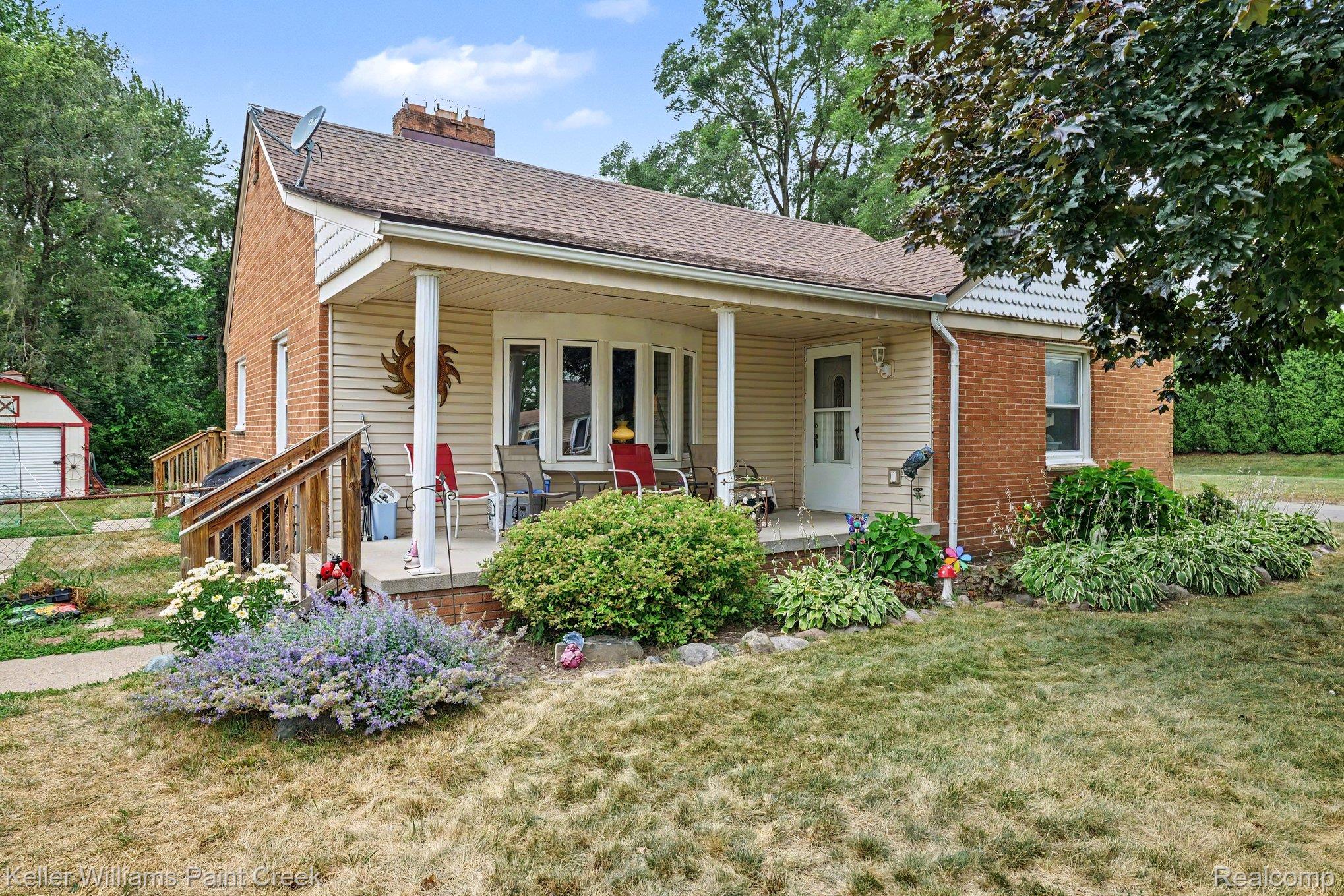 2340 Hessel Avenue Rochester, MI 48307 - Photo 2 of 25 Ranch-style residence featuring brick and siding exterior, a covered front porch with white columns, a bay window, and a wood ramp entry