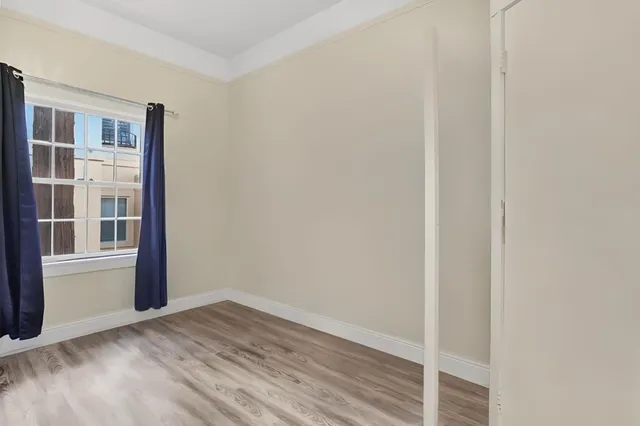 a view of empty room with wooden floor and entryway