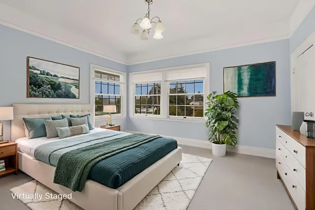 a bedroom with a large bed and a potted plant