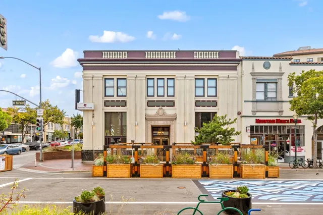 a front view of a building with a tree