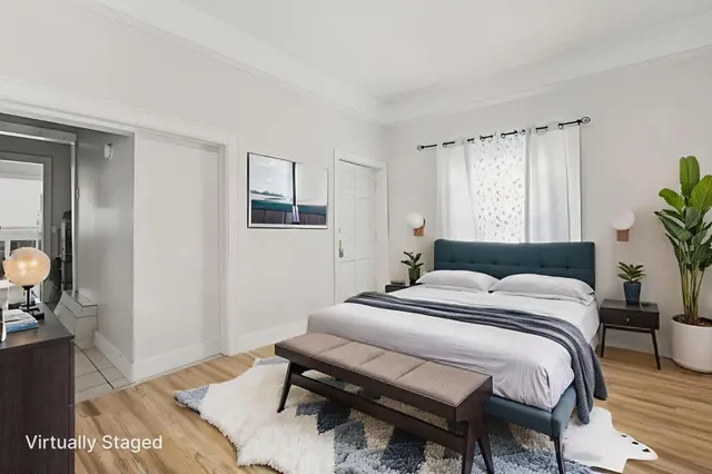 a bedroom with a bed and wooden floor