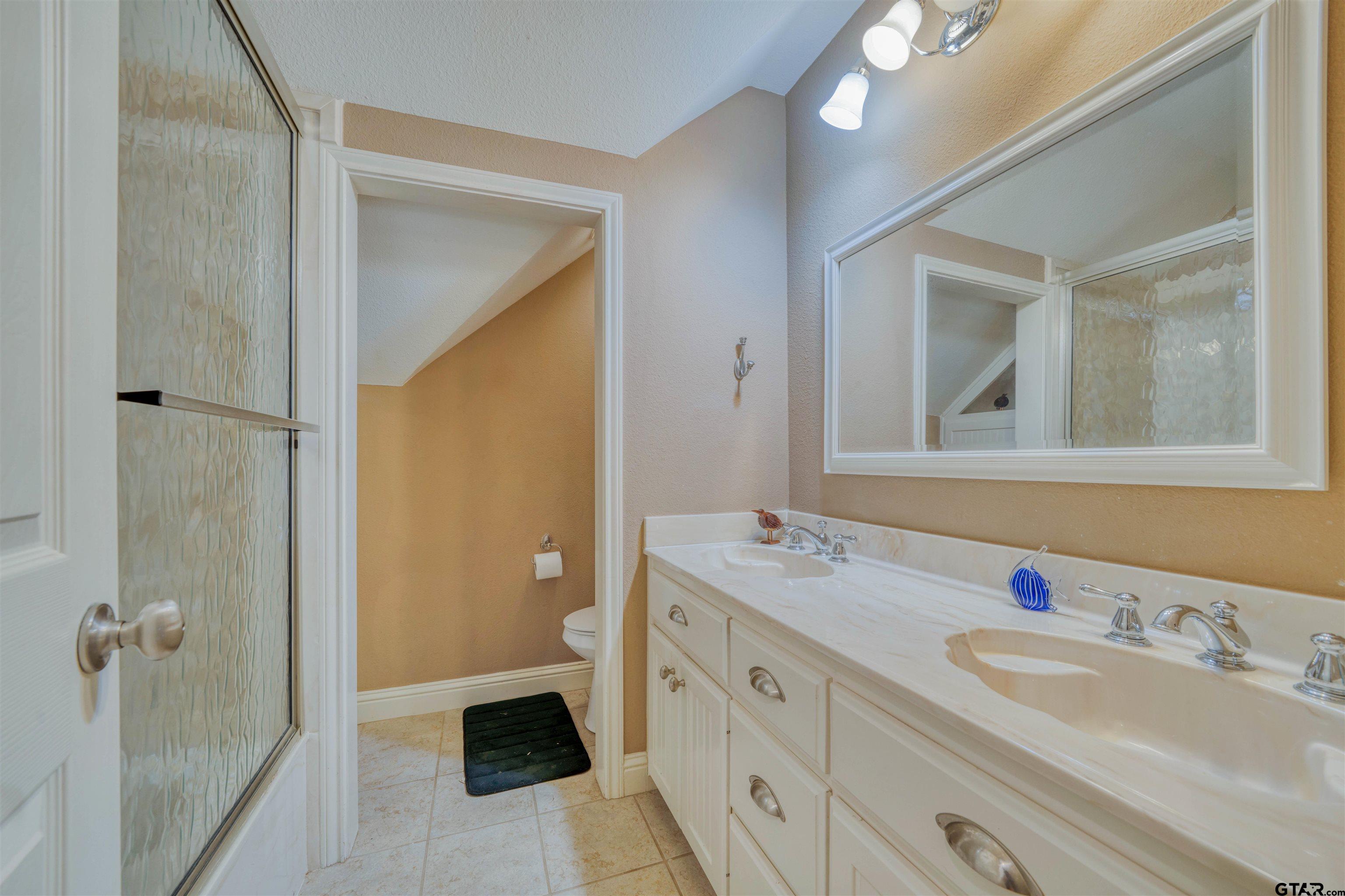 1776 Mustang Road Gilmer, TX 75645 - Photo 39 of 45 a bathroom with a double vanity sink and mirror with shower