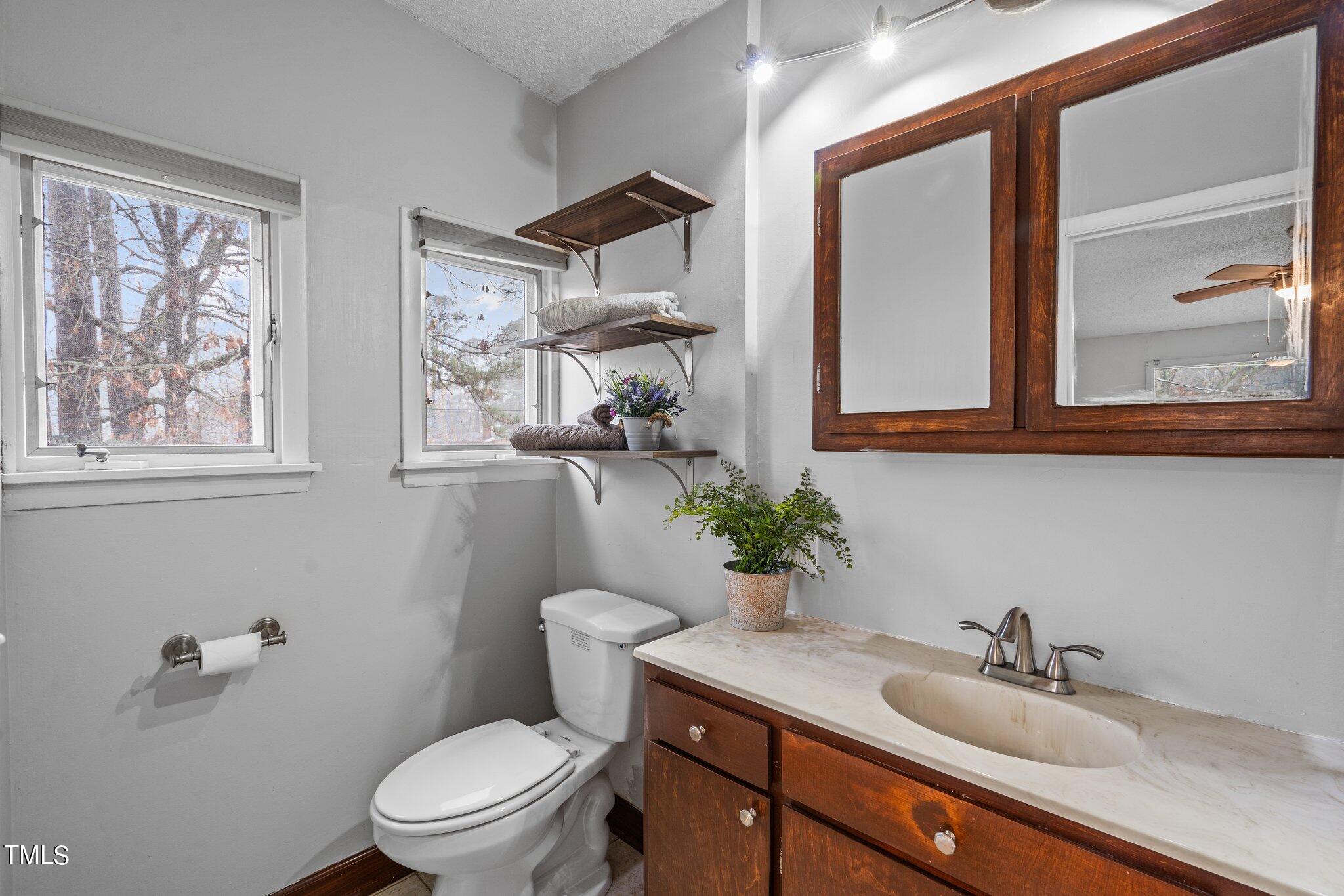 3500 Baugh Street Raleigh, NC 27604 - Photo 14 of 34 a bathroom with a toilet a sink and mirror