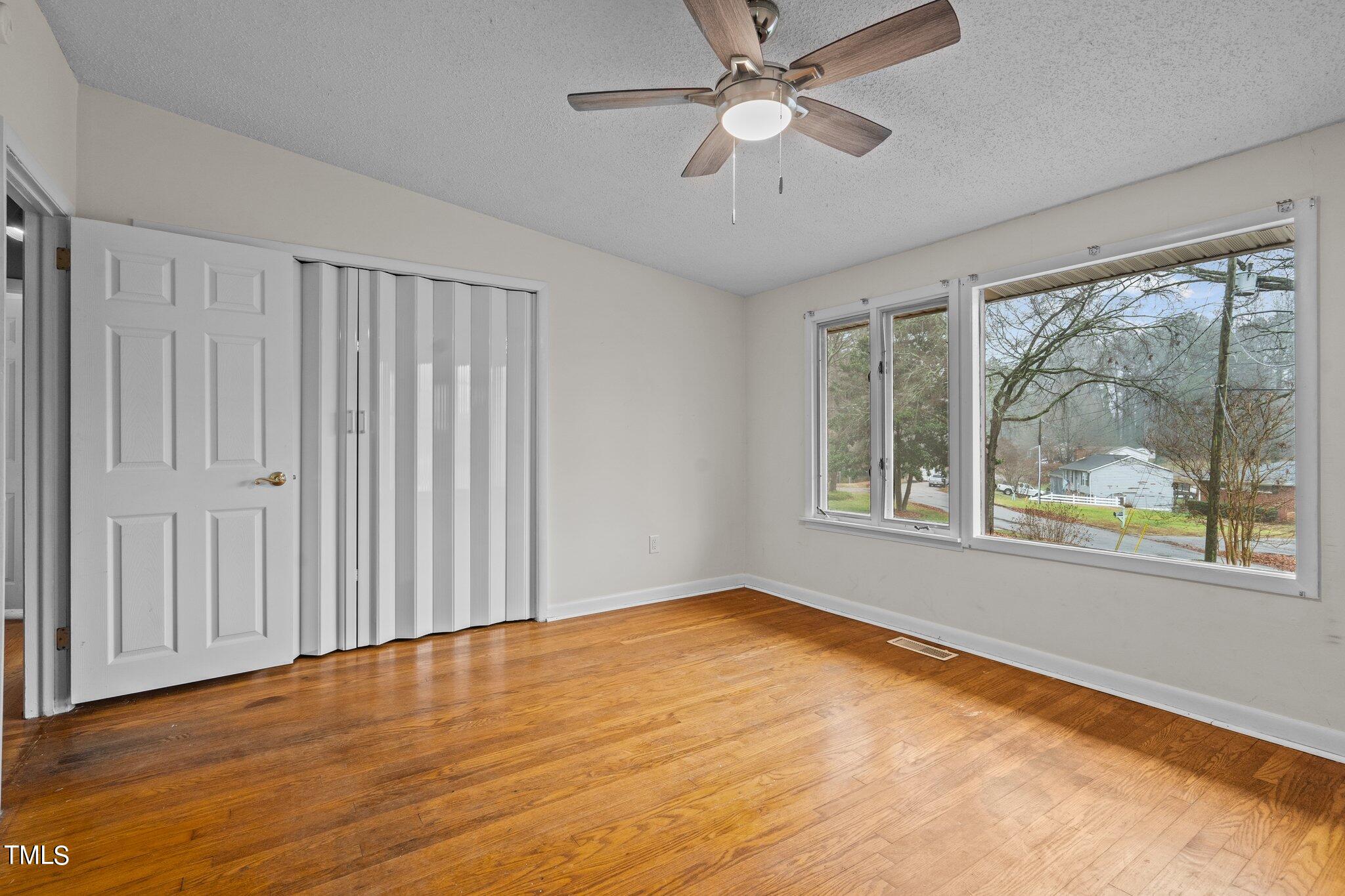 3500 Baugh Street Raleigh, NC 27604 - Photo 16 of 34 an empty room with wooden floor fan and windows