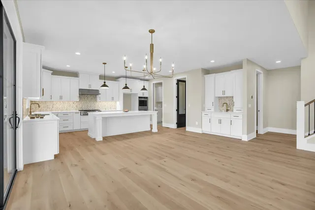 a view of empty room with wooden floor and ceiling fan