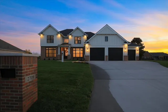 a front view of a house with a yard and trees