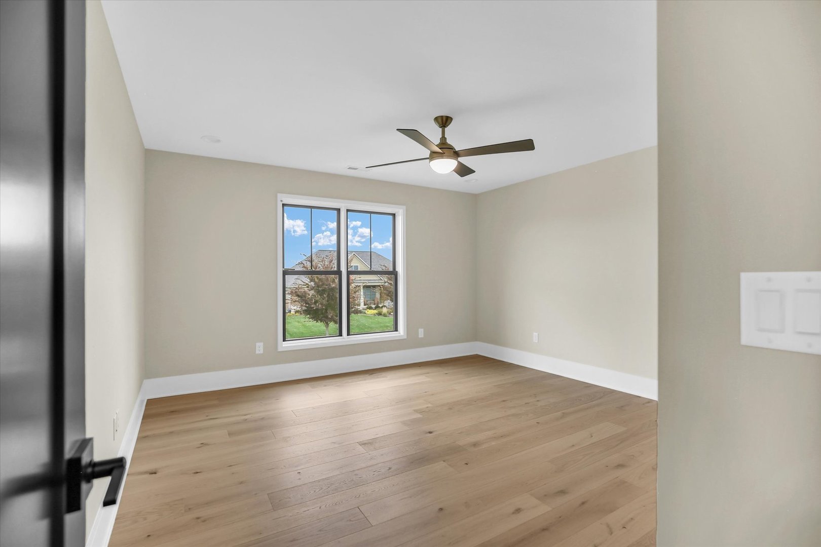 2709 East Castlerock Drive Urbana, IL 61802 - Photo 67 of 117 a view of an empty room with a window and wooden floor