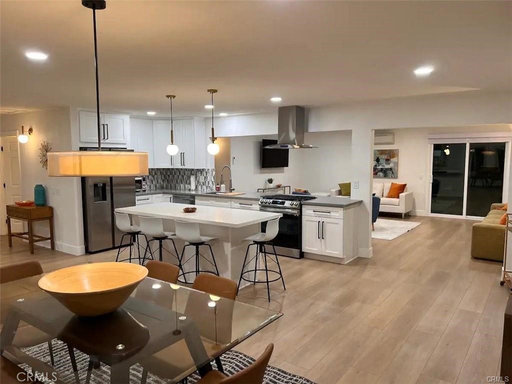 41830 6th Street Temecula, CA 92590 - Photo 3 of 8 a kitchen with stainless steel appliances kitchen island granite countertop a sink a stove a dining table and chairs