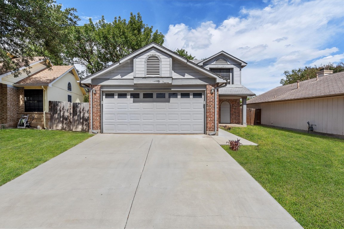 a front view of a house with a garden and yard