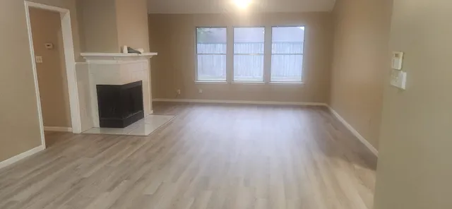 an empty room with wooden floor and a window