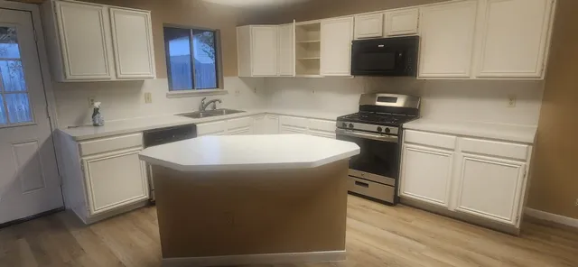 a kitchen with a sink appliances and cabinets