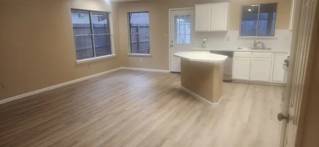 a view of a kitchen with wooden floor and windows