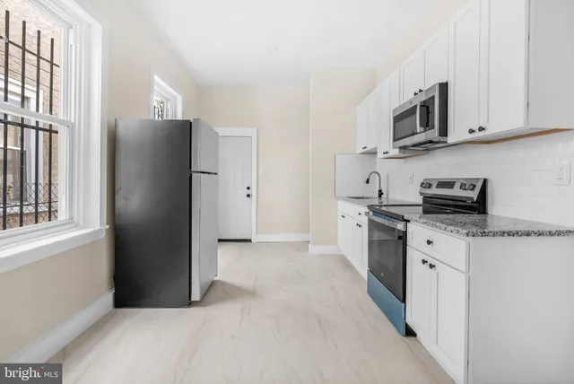 a kitchen with stainless steel appliances granite countertop a refrigerator a stove top oven a sink and dishwasher