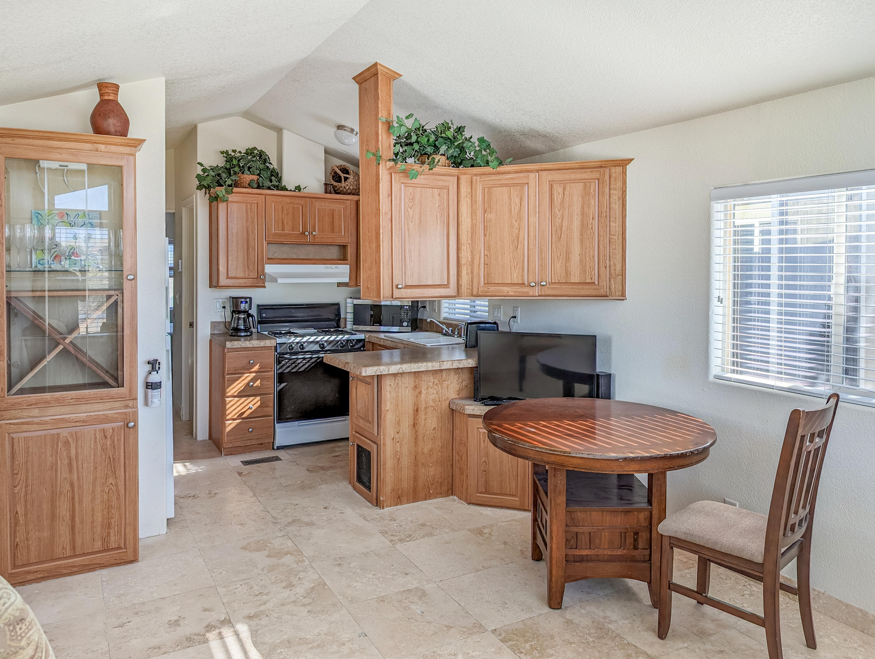 70200 Dillon Road, Unit 328 Desert Hot Springs, CA 92241 - Photo 11 of 25 a kitchen with a table chairs sink and cabinets