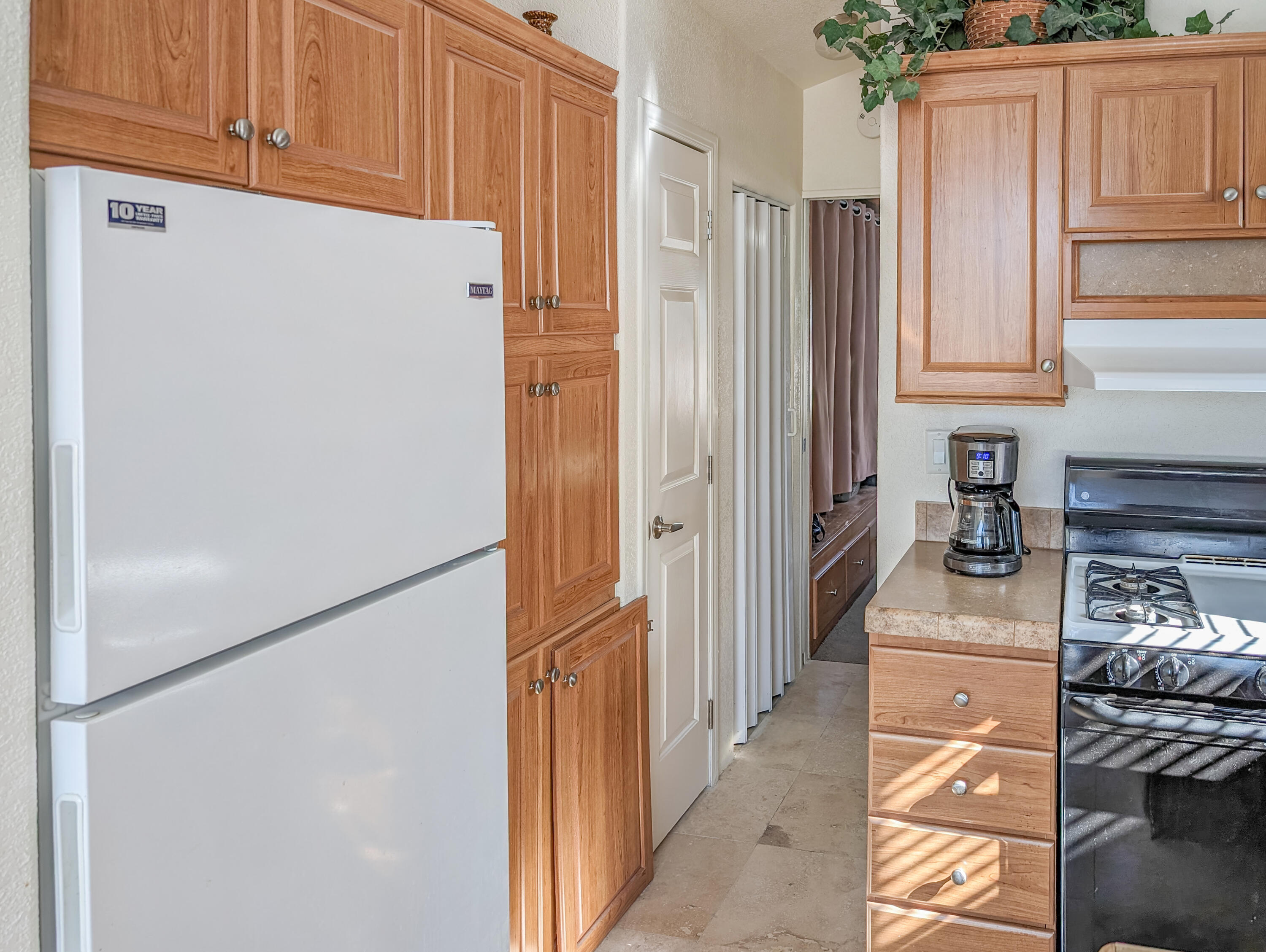 70200 Dillon Road, Unit 328 Desert Hot Springs, CA 92241 - Photo 15 of 25 a kitchen with a refrigerator and a stove