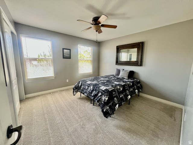 369 Culross Circle Tooele, UT 84074 - Photo 29 of 54 Carpeted room featuring a ceiling fan with light fixture, two windows with blinds, and white baseboards