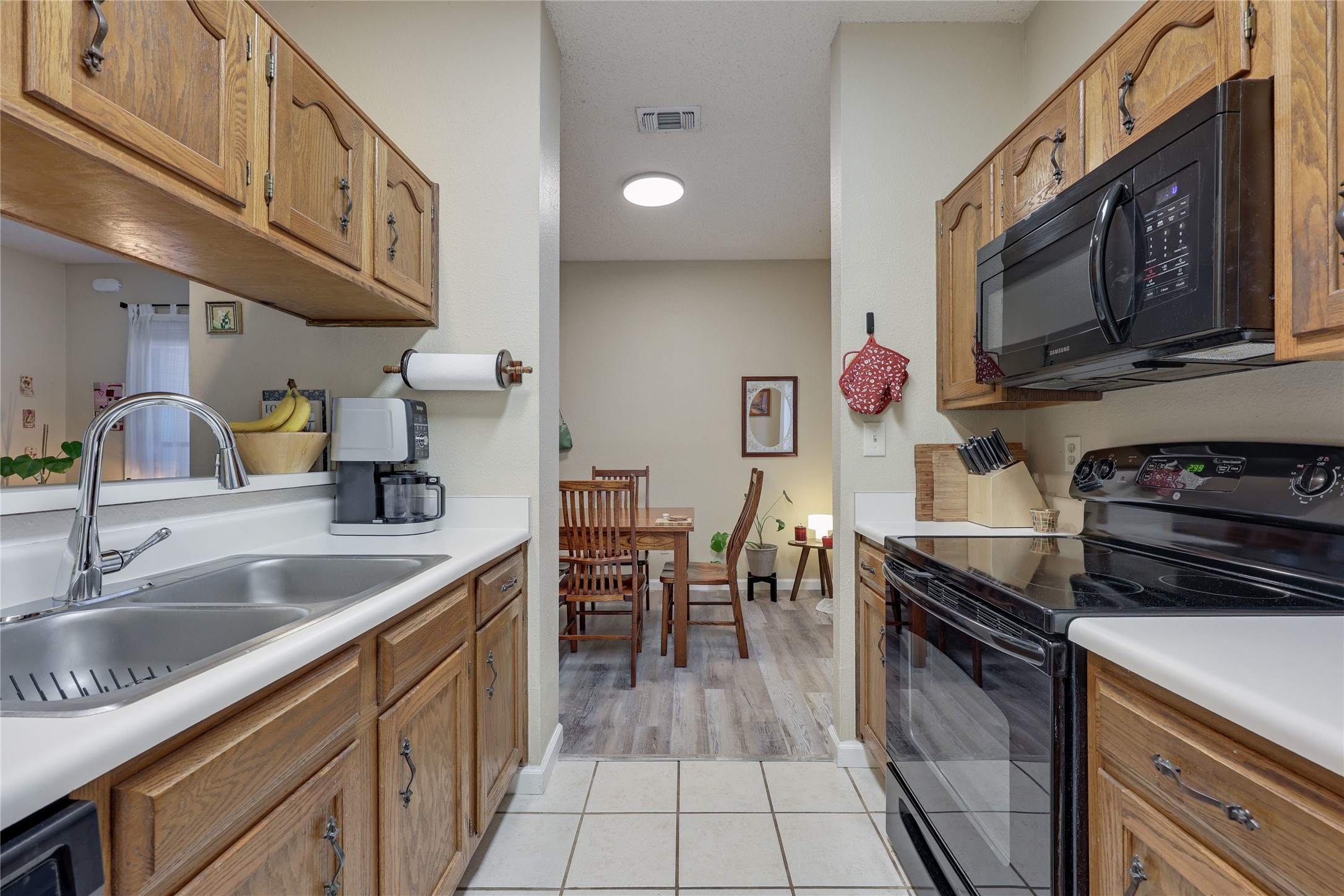 3011 Fruth Street, Unit 101 Austin, TX 78705 - Photo 5 of 14 A well-equipped kitchen boasts a dual-basin sink and full-size appliances, seamlessly connecting to a cozy dining area.