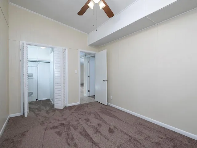 an empty room with chandelier fan
