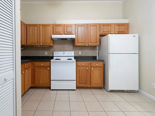 a kitchen with a stove top oven and cabinets