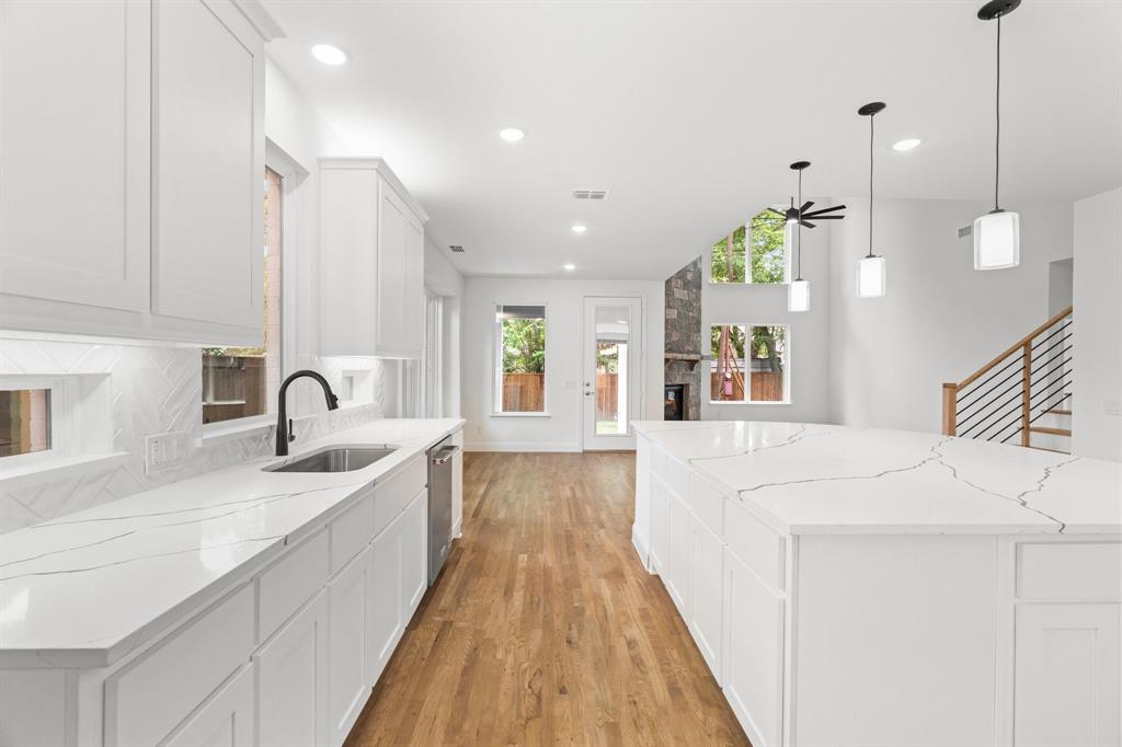 848 Northwood Road Fort Worth, TX 76107 - Photo 19 of 40 a view of a kitchen with kitchen island a sink wooden floor and a large window