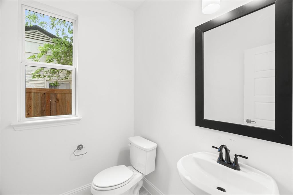 848 Northwood Road Fort Worth, TX 76107 - Photo 5 of 40 a bathroom with a sink a mirror and a toilet