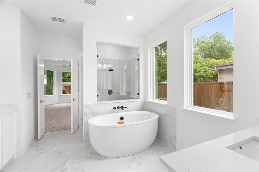 848 Northwood Road Fort Worth, TX 76107 - Photo 10 of 40 a white bath tub sitting in a bathroom next to a bathroom sink