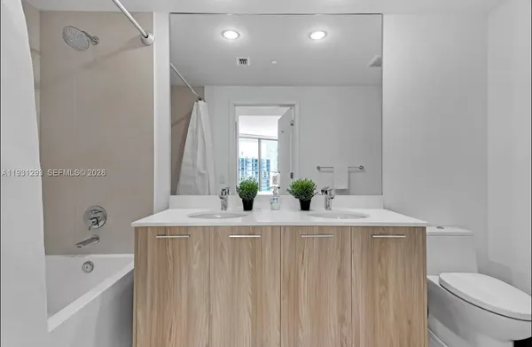 a bathroom with a granite countertop sink a toilet and shower