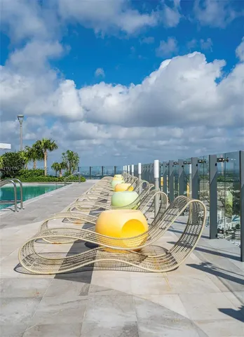 a view of a swimming pool with a patio and a yard