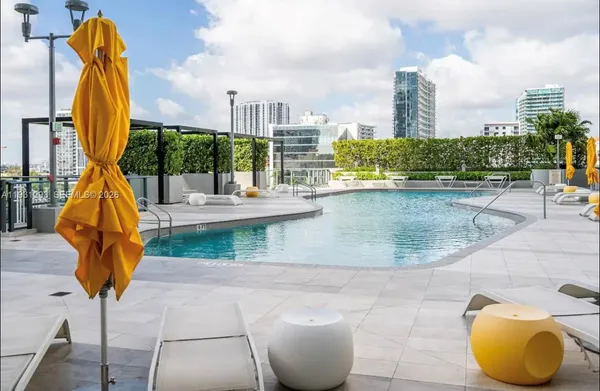 a view of a swimming pool with a terrace and city view